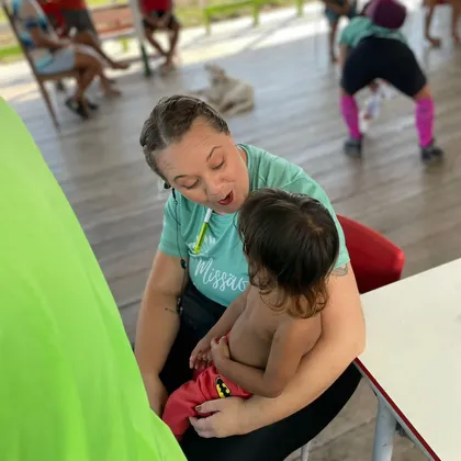 Luciene com uma criança no colo durante atendimento