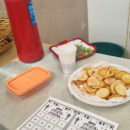 Mesa de lanche com cartelas de bingo junino